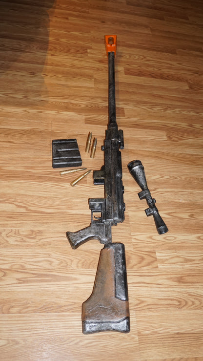 a toy gun with a scope and a toy bullet on a wooden floor.